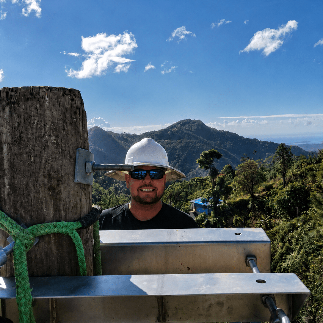 Journeyman lineman working high on a utility structure in the mountains of Puerto Rico