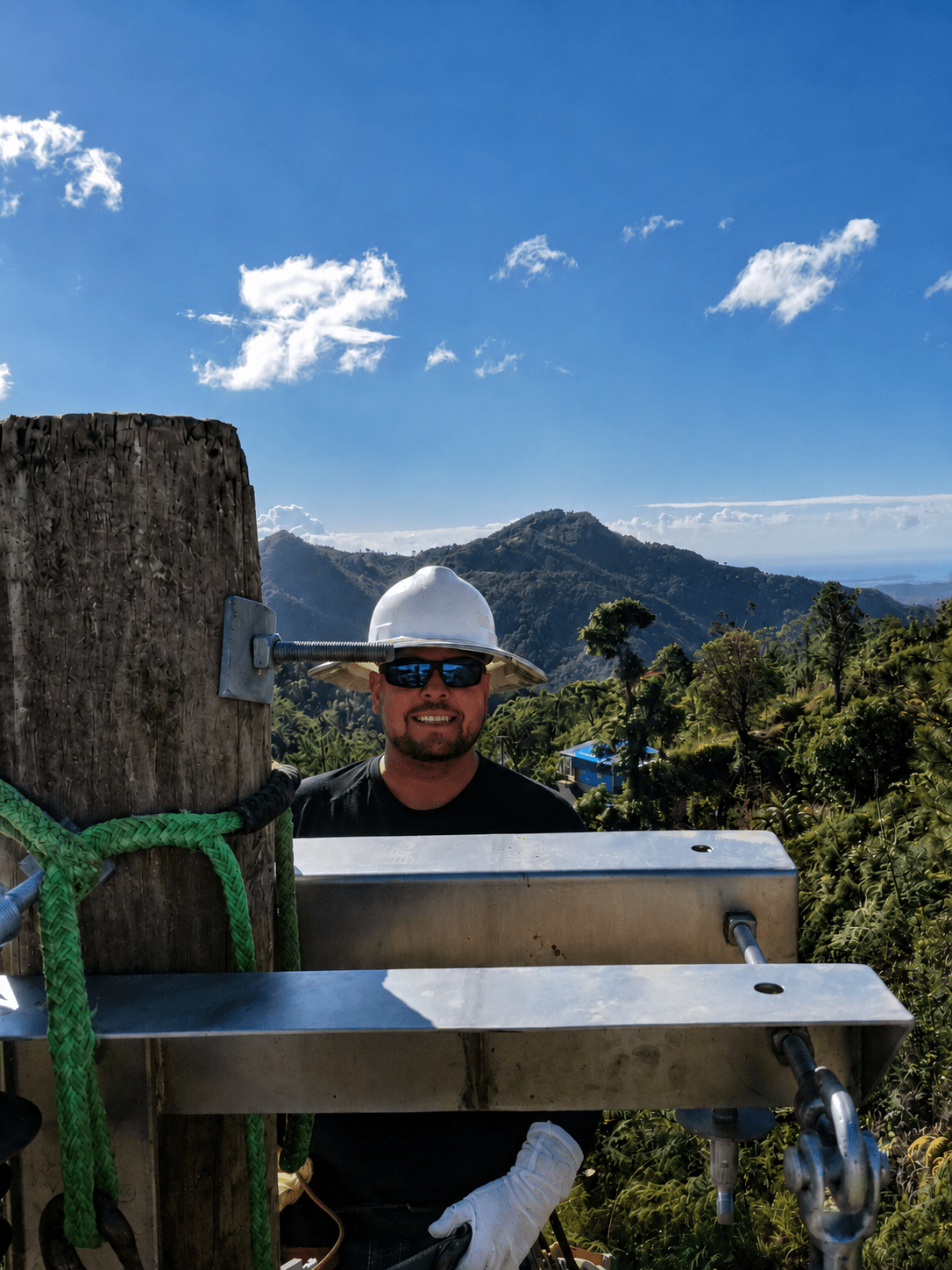 Journeyman lineman working high on a utility structure in the mountains of Puerto Rico