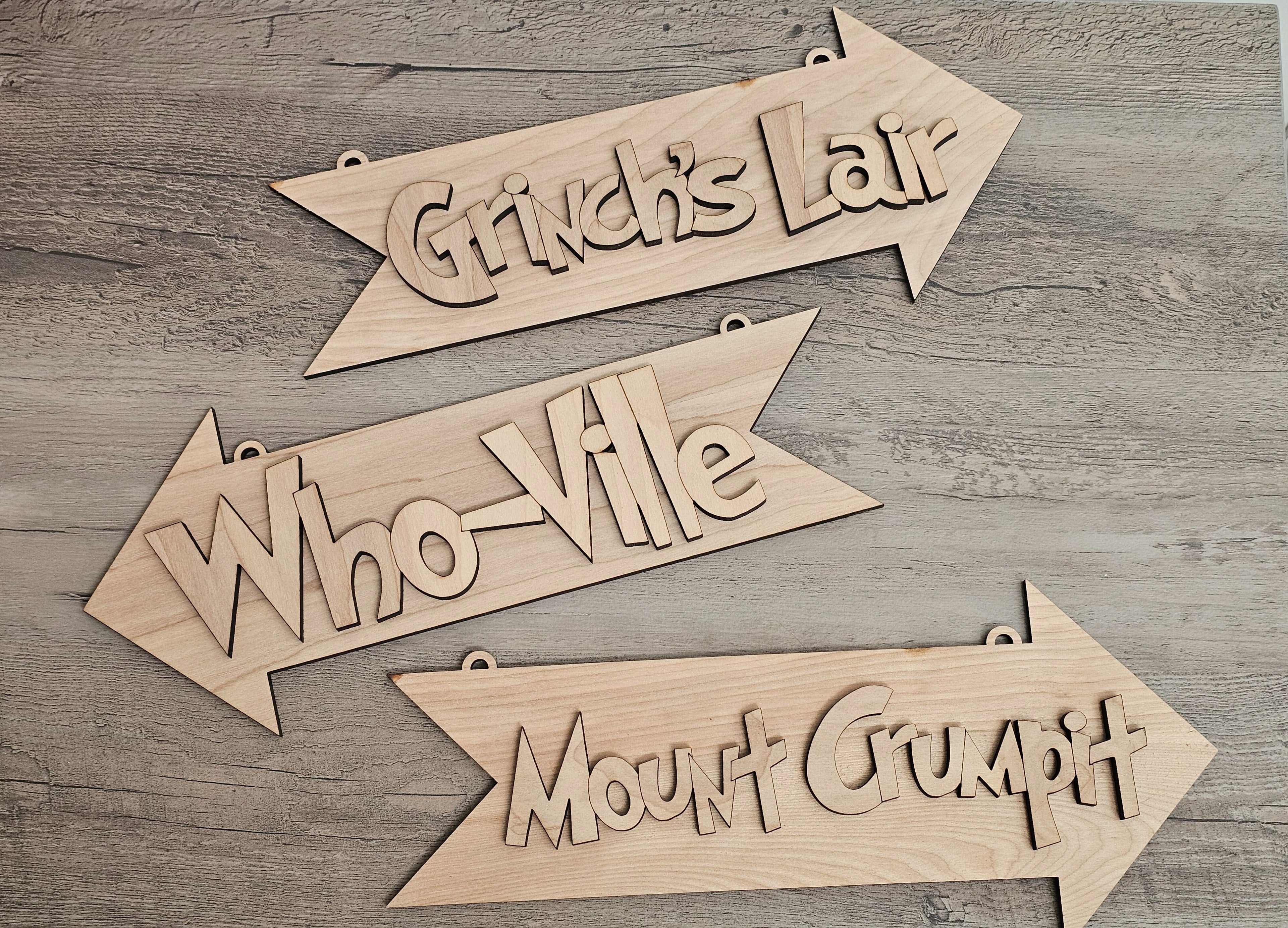 Wooden arrow-shaped signs with text on a wooden surface
