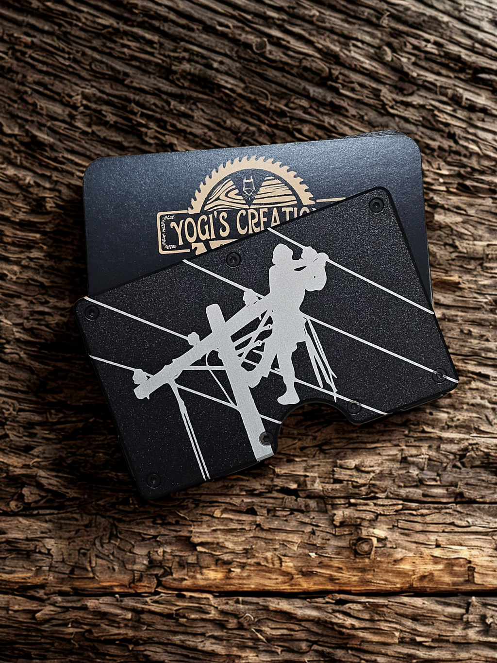 Black leather wallet with white design on a wooden surface, featuring 'Yogi's Creations' branding.