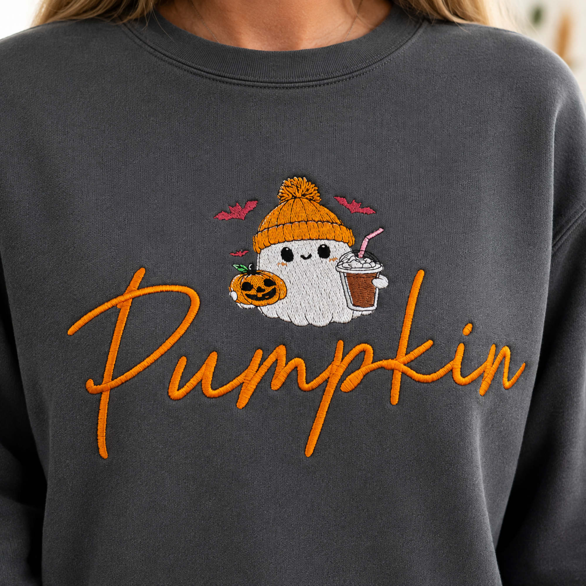 Close-up of ghost, jack-o-lantern and orange Pumpkin script embroidery on Pepper sweatshirt