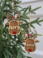 Wooden deer-shaped ornaments with names 'Avery' and 'Hunter' on a Christmas tree.