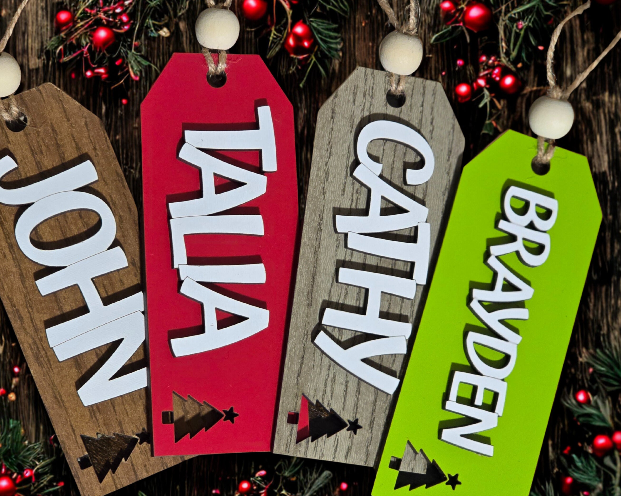 Wooden name tags with names 'John', 'Talia', 'Cathy', and 'Brayden' on a festive background.