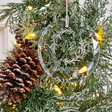 Close view of the personalized glass ornament showing its faceted beveled edge and engraving