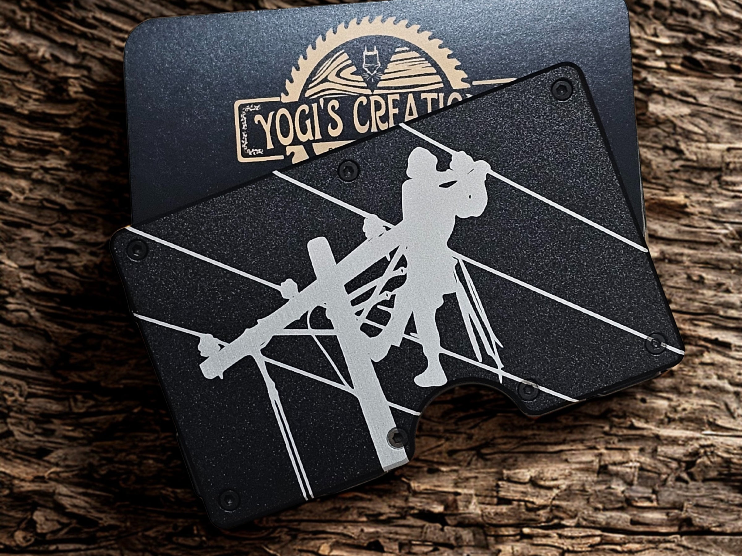 Black lineman wallet money clip with engraved utility worker design on rustic wood background