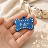 Blue crystal pet ID tag shown in hand for size reference