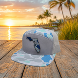 Angled view of saltwater blue camo Florida UV printed patch Richardson flat bill trucker hat