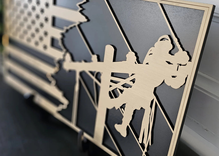Angled close-up of personalized lineman flag plaque showing layered wood detail and black backing