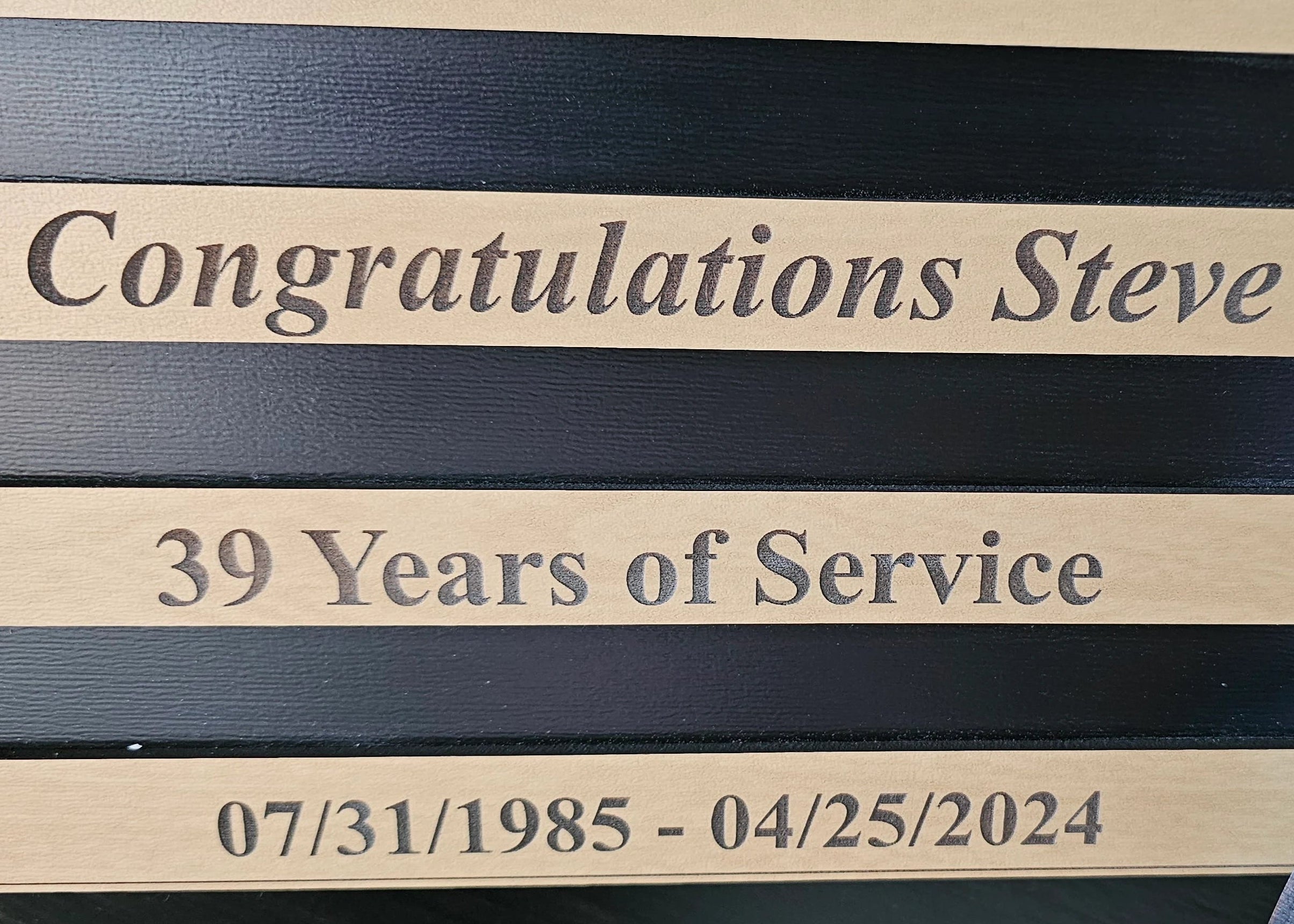 Close-up of custom text on a personalized lineman plaque for retirement and years of service