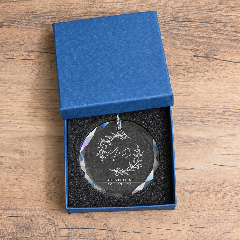 Engraved beveled glass ornament displayed inside its lined blue presentation box