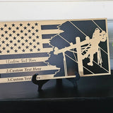 Personalized lineman flag plaque displayed on a black shelf with plant decor and included tabletop stand