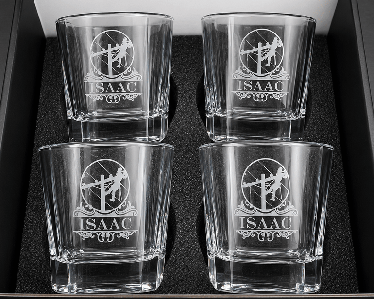 Four personalized lineman whiskey glasses with engraved designs arranged in a gift box