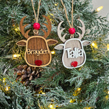 Personalized reindeer Christmas ornaments in Walnut and Whitewash hanging together on a lit Christmas tree