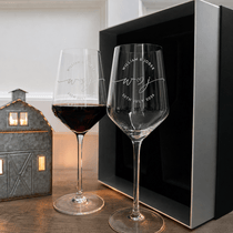 One filled and one empty personalized wine glass displayed with the matching gift box