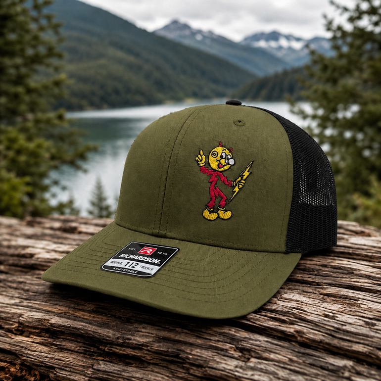Reddy Kilowatt embroidered Loden / Black Richardson 112 trucker hat outdoors