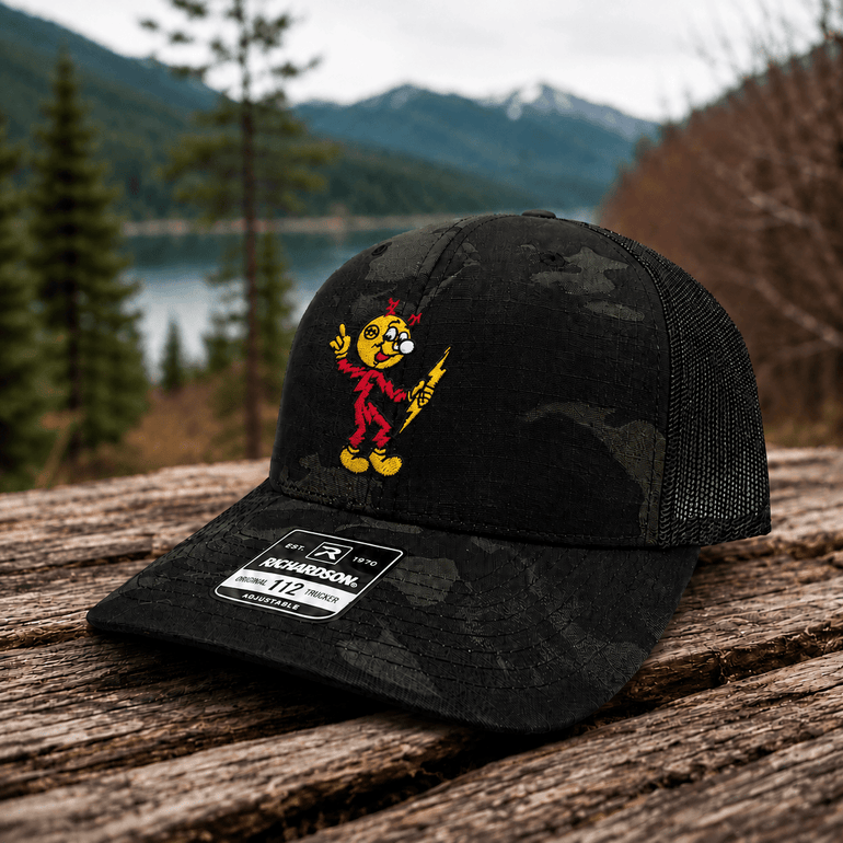 Reddy Kilowatt embroidered Multicam Black / Black Richardson trucker hat with centered front logo outdoors