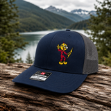 Reddy Kilowatt embroidered Navy / Charcoal Richardson 112 trucker hat outdoors