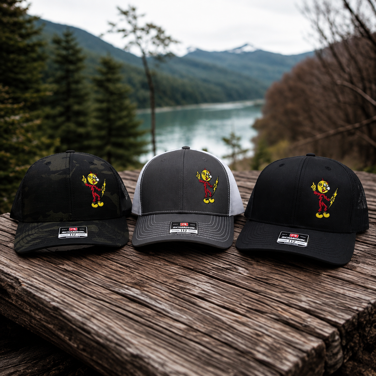 Black / Black, Charcoal / White, and Multicam Black / Black Reddy Kilowatt embroidered hats outdoors